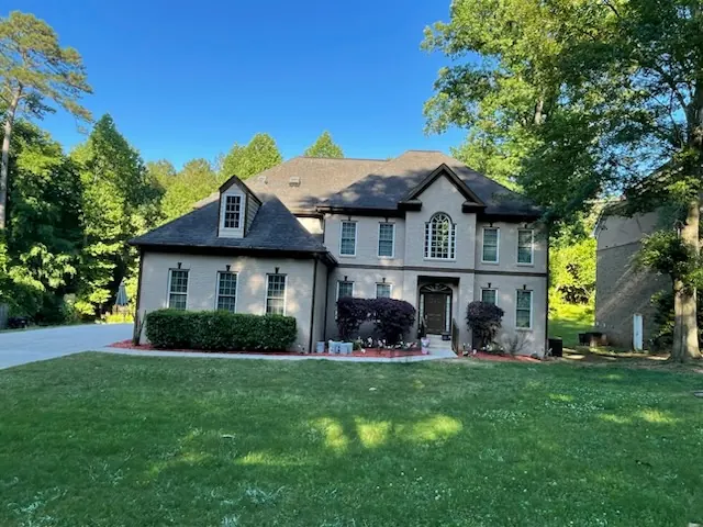 Brick home front after painting, with dark trim